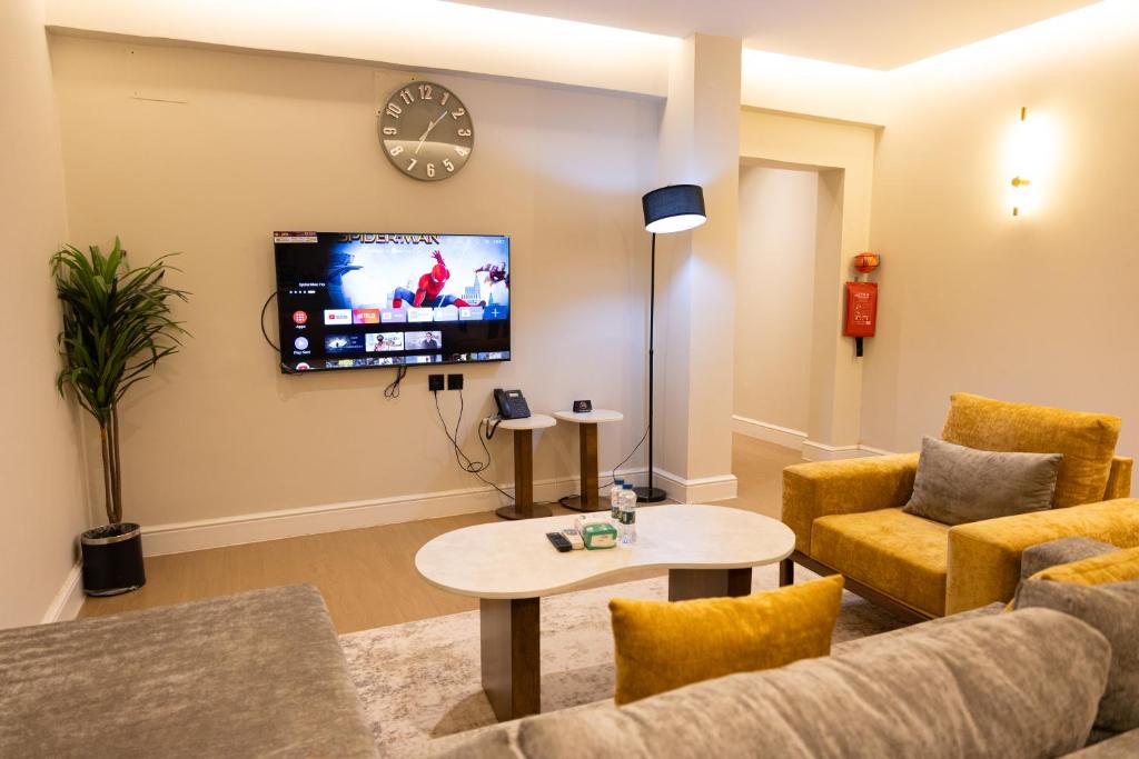 a living room with a couch and a tv on a wall at فندق دواد الدوادمي Dewad Hotel in Ad Dawādimī