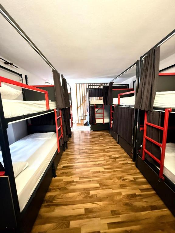 a room with three bunk beds and a wooden floor at Majka Guest House in Kotor