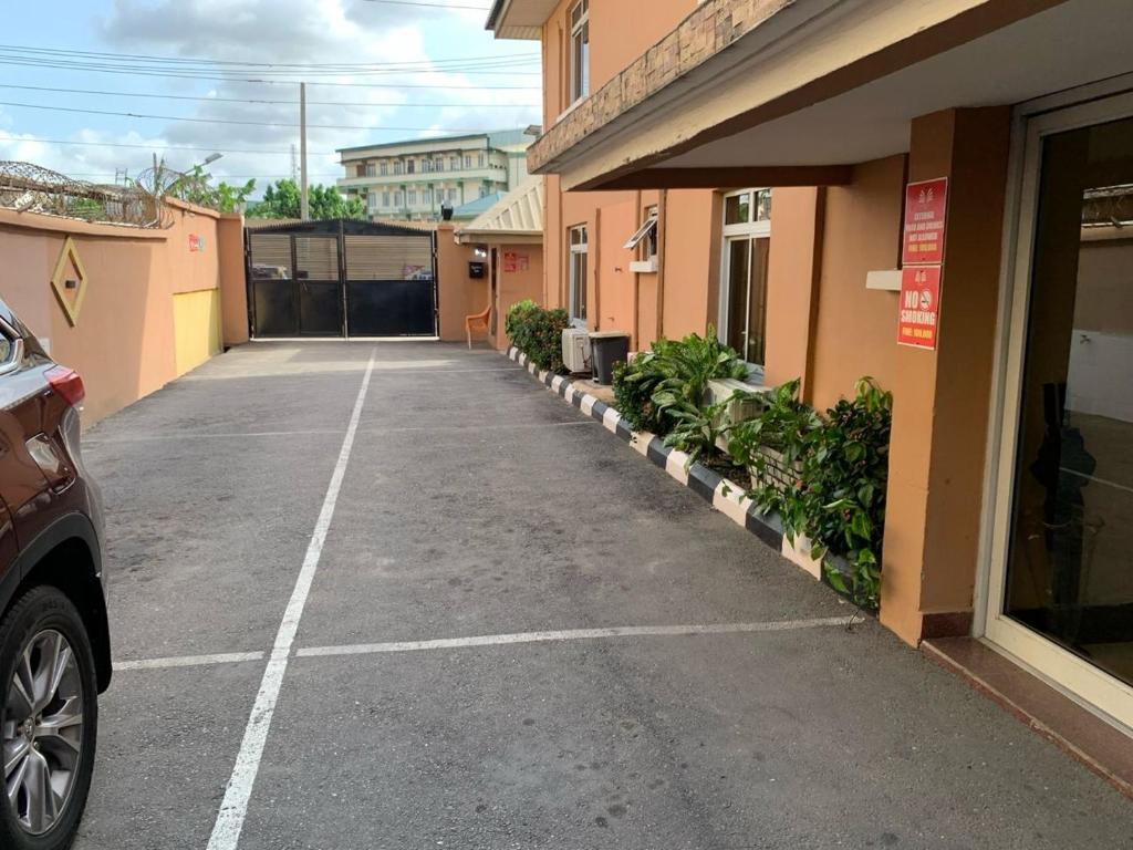 a car parked in a parking lot next to a building at Trendy Inn limited in Lagos