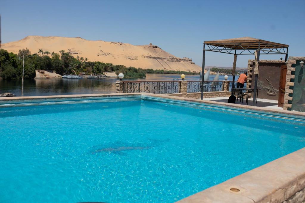 a large blue swimming pool with a view of a river at Island House in Jazīrat Aswān