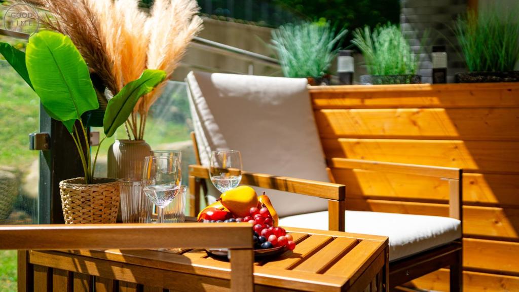 a table with wine glasses and fruit on a patio at Apartamenty Good Time- Centrum, blisko wyciągu i szlaków in Szklarska Poręba