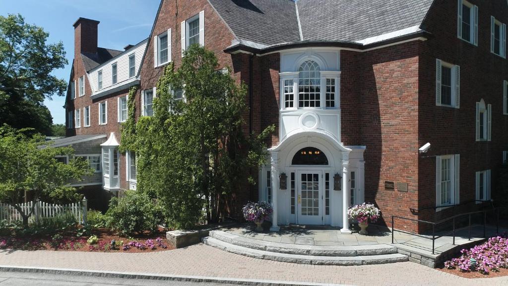 a large brick house with a white door at The Spa at Norwich Inn in Norwich