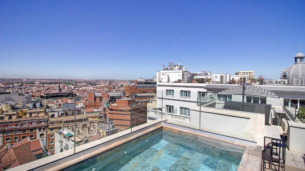 a swimming pool on top of a building with a city at Pestana CR7 Gran Vía Madrid in Madrid