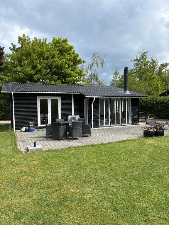 a small house with a patio and a yard at Summer House Near The Sea And Good Experiences in Børkop