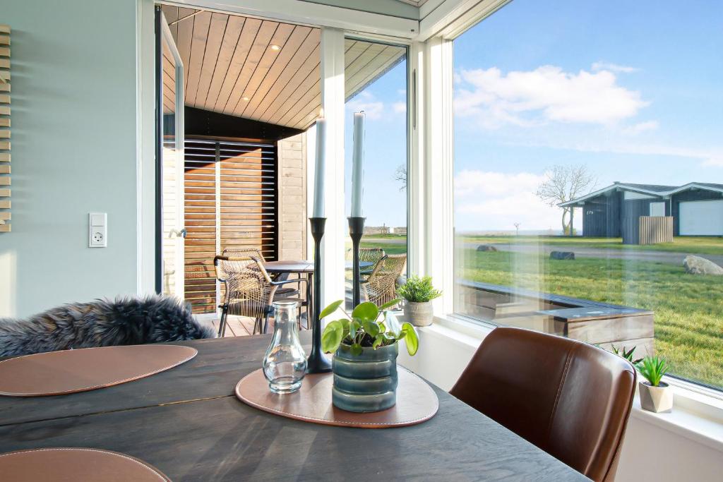 a dining room with a table and a large window at New Modern Holiday Home Near The Beach in Aabenraa