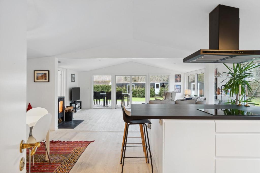 a kitchen and living room with white cabinets and a counter at Relaxing Sanctuary In Desirable Area in Hornbæk