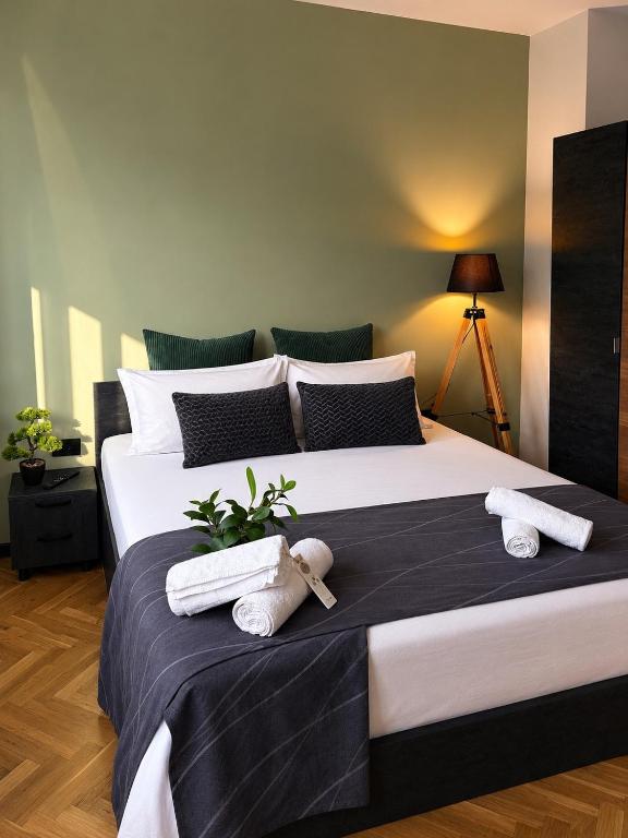 a bedroom with a large bed with towels on it at Avliga Designer Residence in Varna City