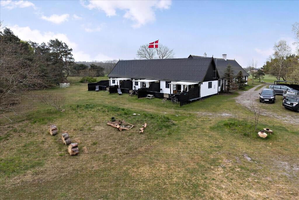 a building with a group of animals in a field at Holiday Apartment In Peaceful Surroundings in Neksø