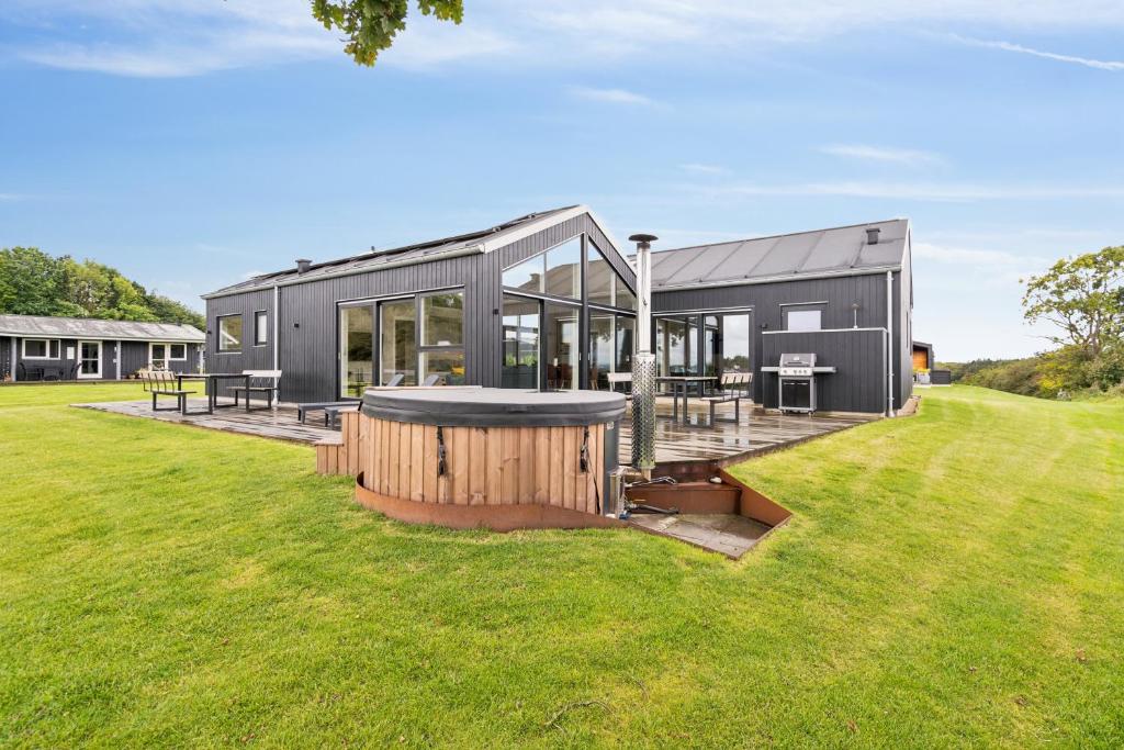 ein graues Haus mit einem großen Garten mit Rasen in der Unterkunft Schönes, Neues Haus Am Meer in Aabenraa