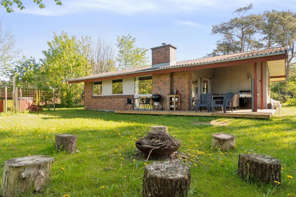 ein Haus mit einem Garten mit Baumstümpfen in der Unterkunft Charmantes Backsteinhaus Mit Sauna Und Fjordblick in Ørsted