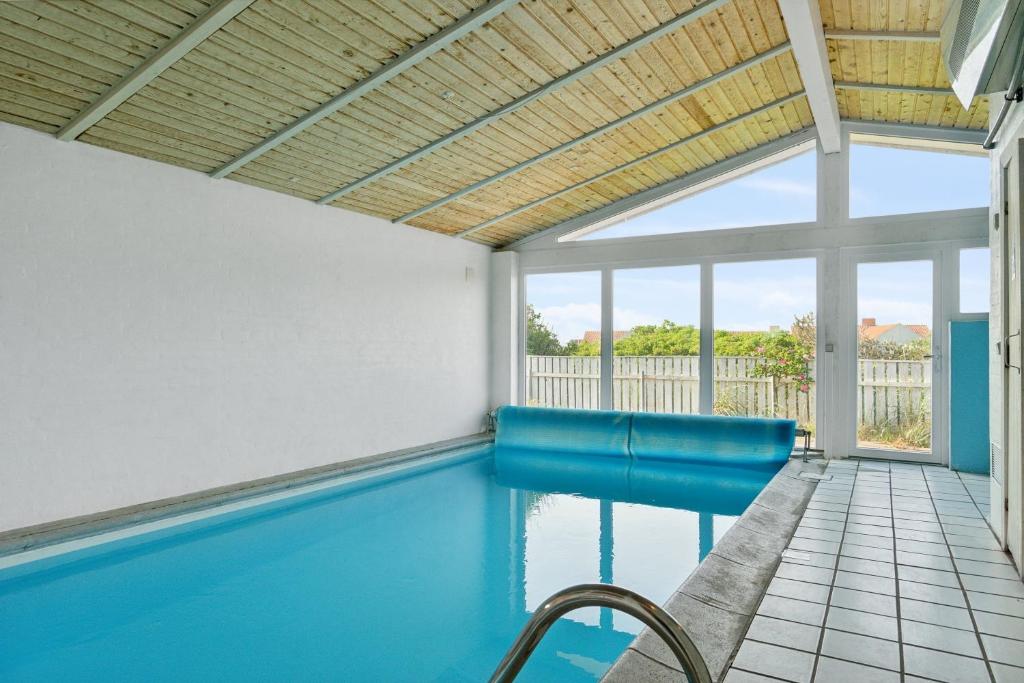 a swimming pool in a house with a ceiling at Pool House Close To The Coast in Vestervig