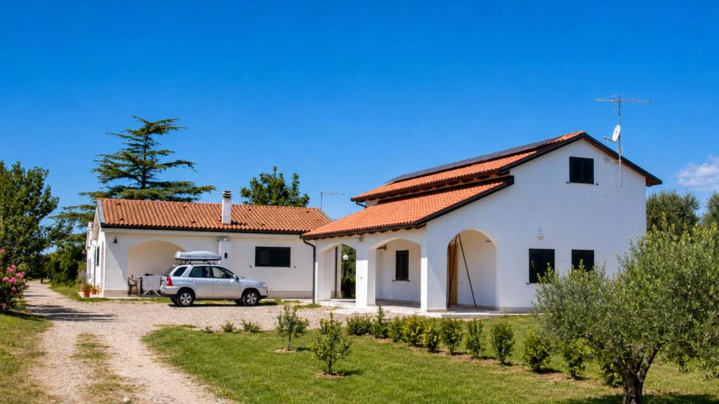 a white house with a car parked in front of it at Casa Vacanze Agriturismo BioMele in Policoro