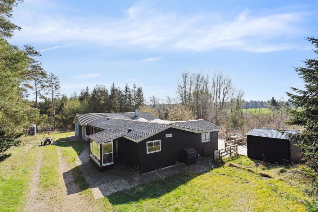 an image of a black house with a yard at Pool House With Space For Relaxation in Bording Stationsby