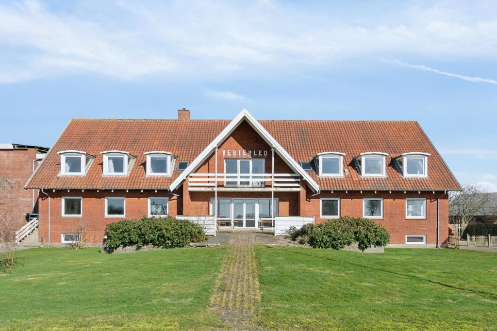a large red brick building with a roof at House For 40 People Near Thy in Gettrup