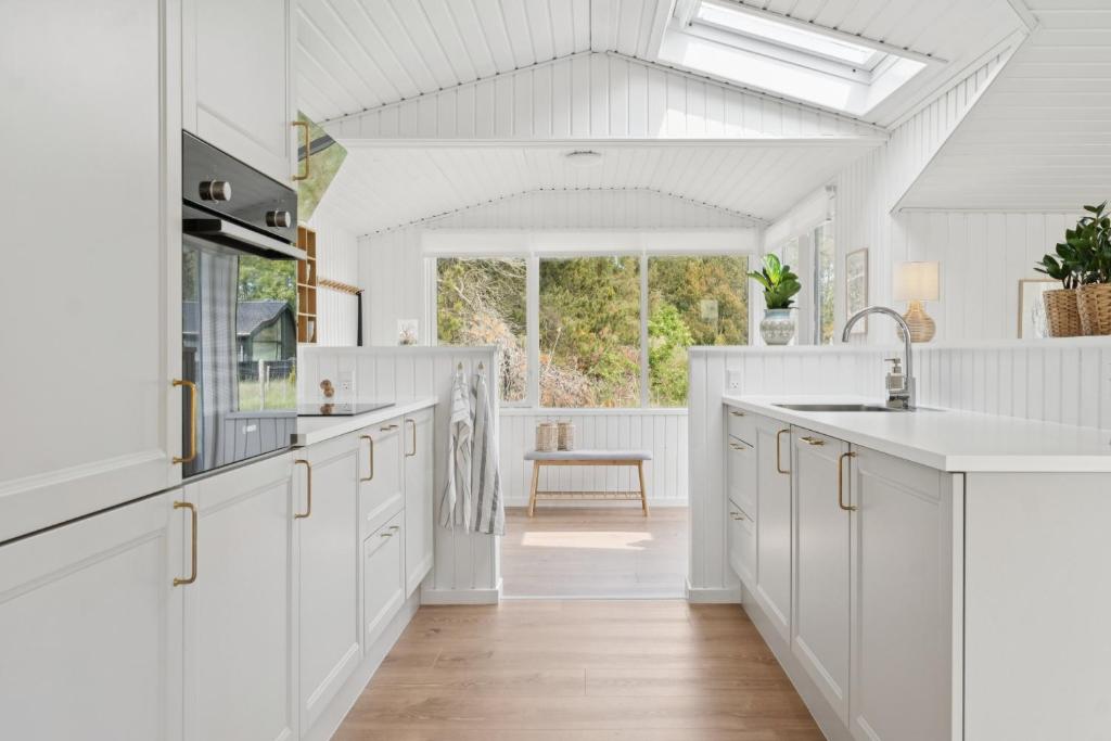 a kitchen with white cabinets and a large window at Scenic Holiday Home In Bratten in Jerup