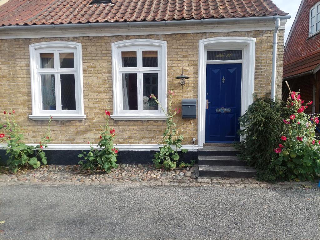 a house with a blue door and two windows at Tordenskjoldet in Marstal