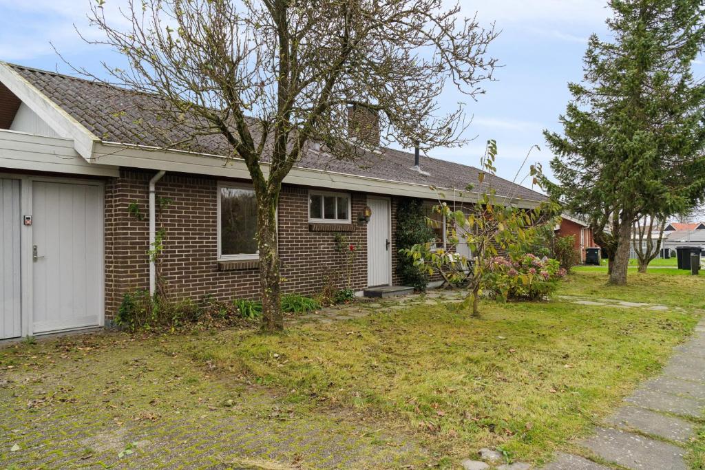 a brick house with a tree in the yard at Cozy Holiday Home In Thisted in Thisted