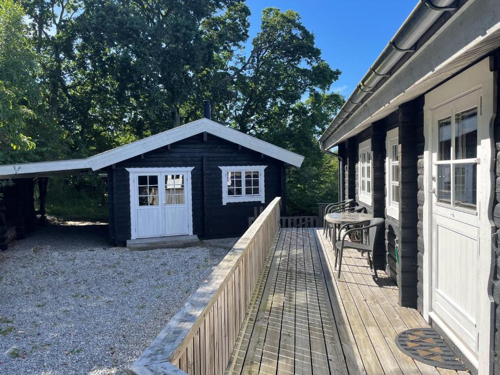 a black shed with a white door next to a house at Cozy Log Cabin With A Panoramic View in Glesborg