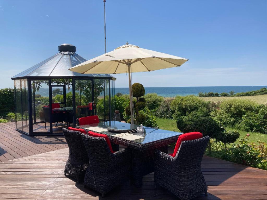 a table with an umbrella and chairs on a deck at Outstanding Close To Nice Beachh in Karrebæksminde