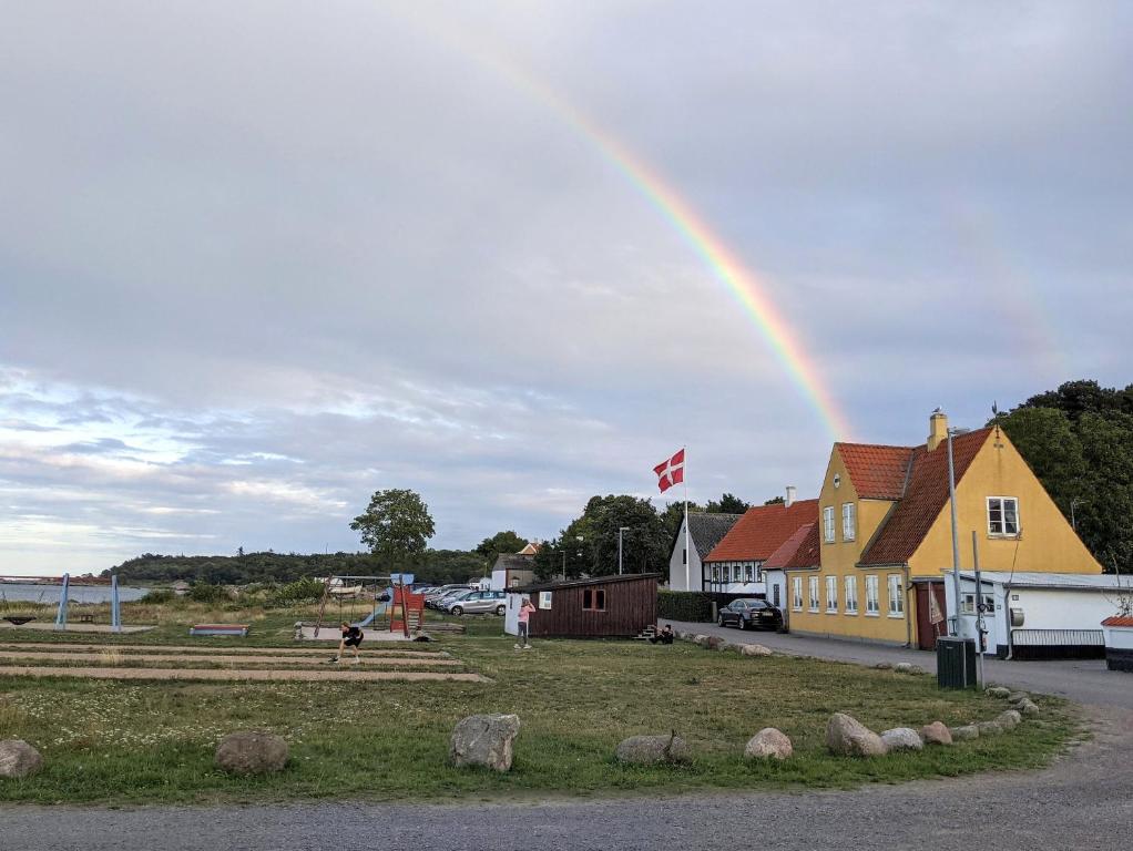 a rainbow in the sky over a town at Lovely 2-Story Cabin By The Sea On Bornholm in Svaneke