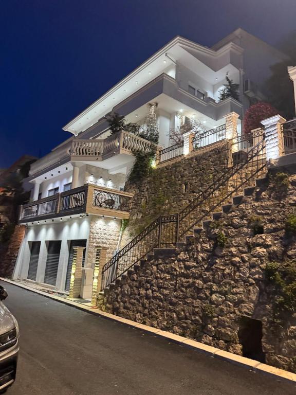 a white house with stairs on a hill at night at Villa LaMia in Ulcinj