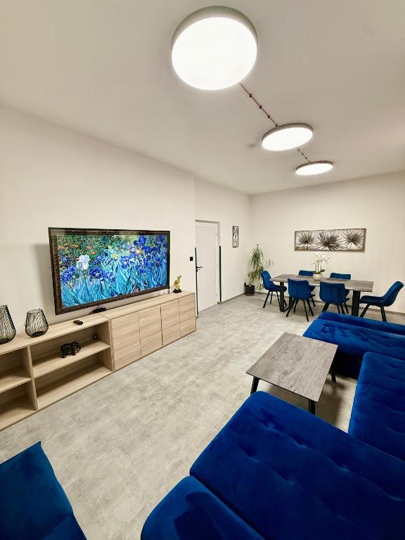 a living room with blue furniture and a flat screen tv at Teplice apartments DELUXE in Teplice