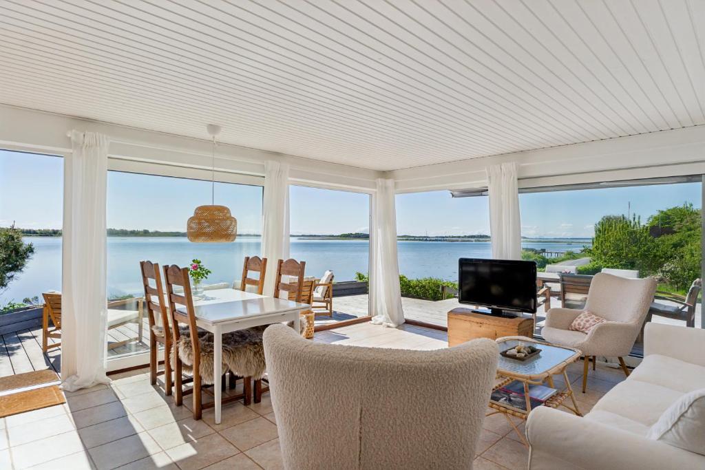a living room with a view of the water at Lovely Beach House With Panoramic View in Martofte