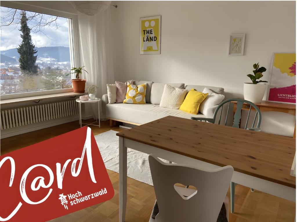 a living room with a couch and a table at Lichtblick unter der Buche in Titisee-Neustadt