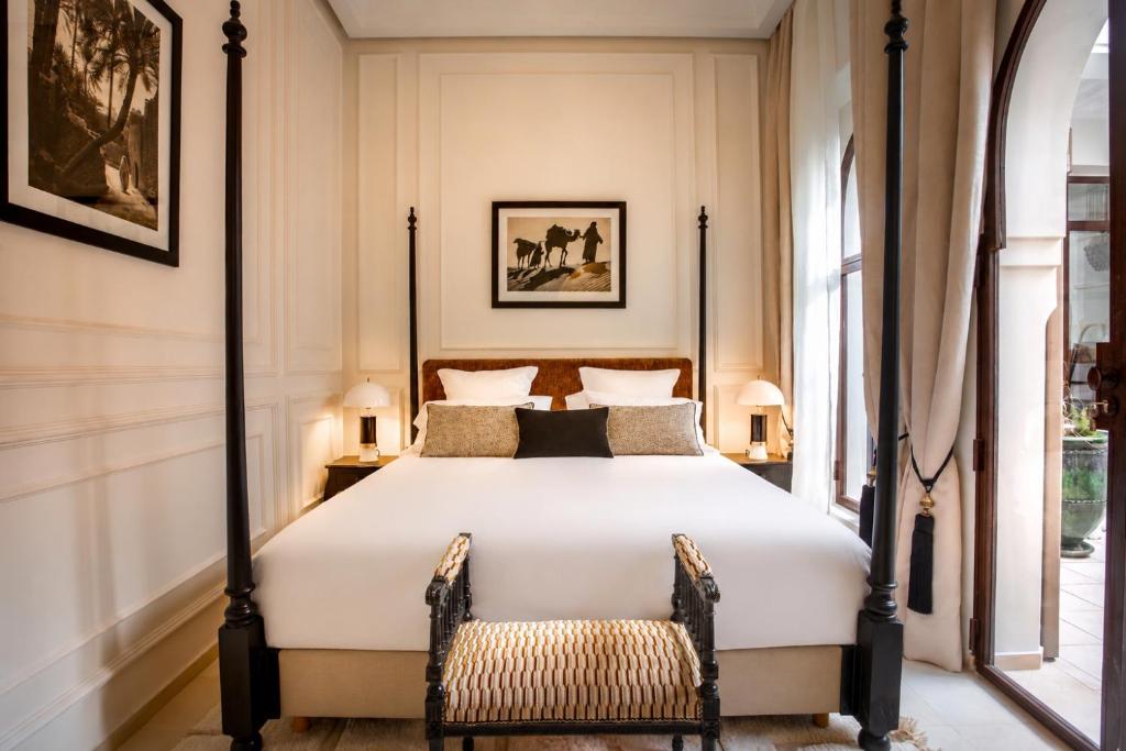 a bedroom with a large white bed and two chairs at Riad Anaqa in Marrakesh