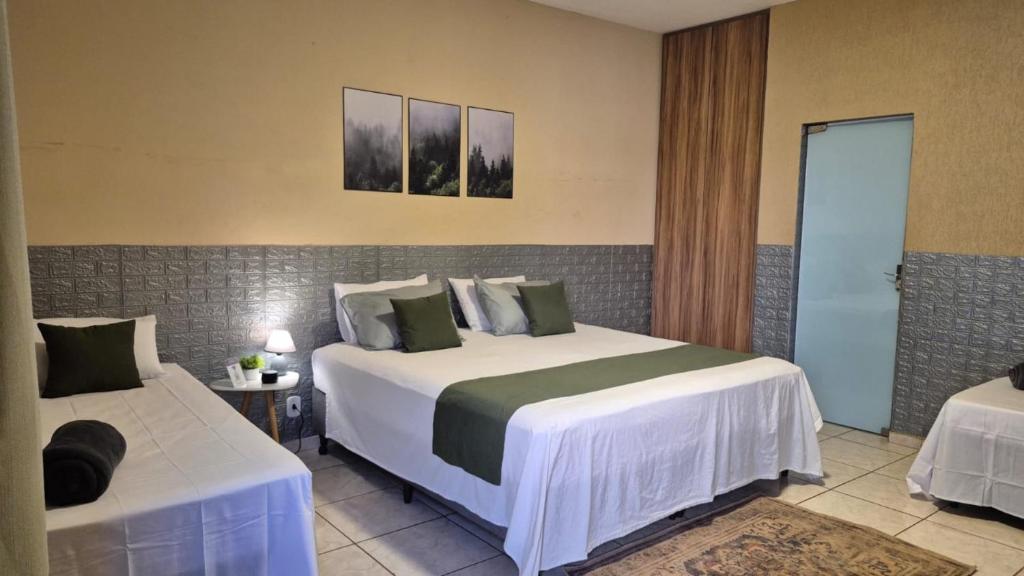 a bedroom with two beds in a room at Suítes privativas, camas confortáveis, piscina, churrasqueira e playground, Roupa de Cama e tolha de banho. in Rubinéia