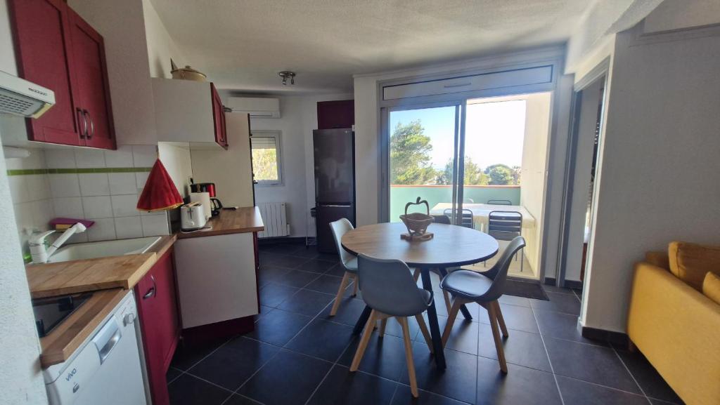 a small kitchen with a table and chairs in a kitchen at Grand T3 face au port avec sa terrasse , parking privatif in Saint-Cyprien-Plage
