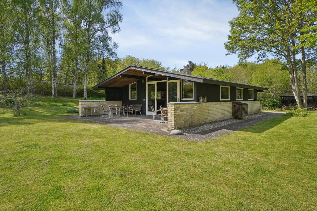 a small house with a patio in a field at Nostalgic 1960S Idyll in Kulhuse