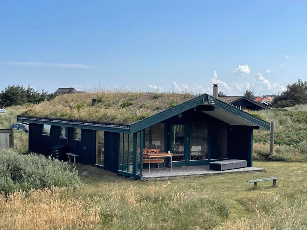 a house with a grassy hill on top of it at 70S Charm Just 300 M From The Beach in Blokhus