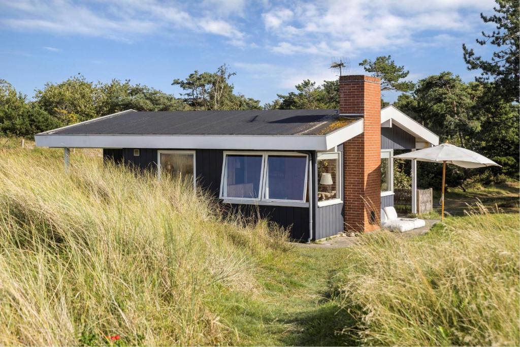 a house on top of a grassy hill at Simple Summer Living In Magical Setting in Nykøbing Sjælland
