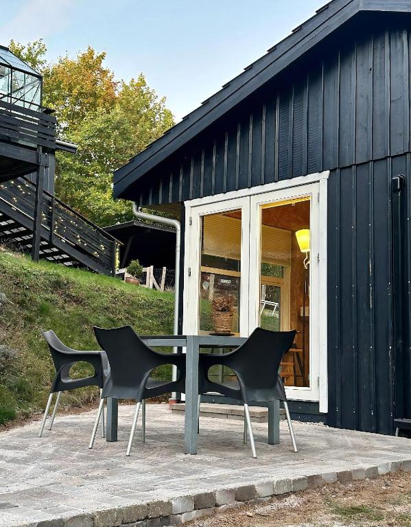 a table and chairs in front of a black building at Small Oasis Near Coast And Town in Ebeltoft