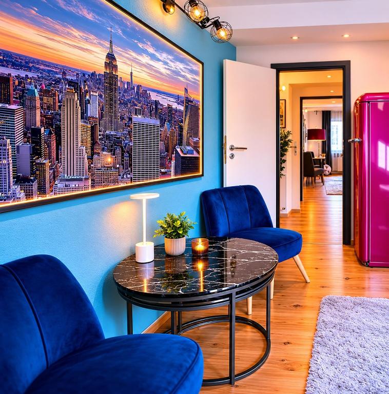 a living room with blue chairs and a table at Bellevue Residence l City Balkon in Koblenz