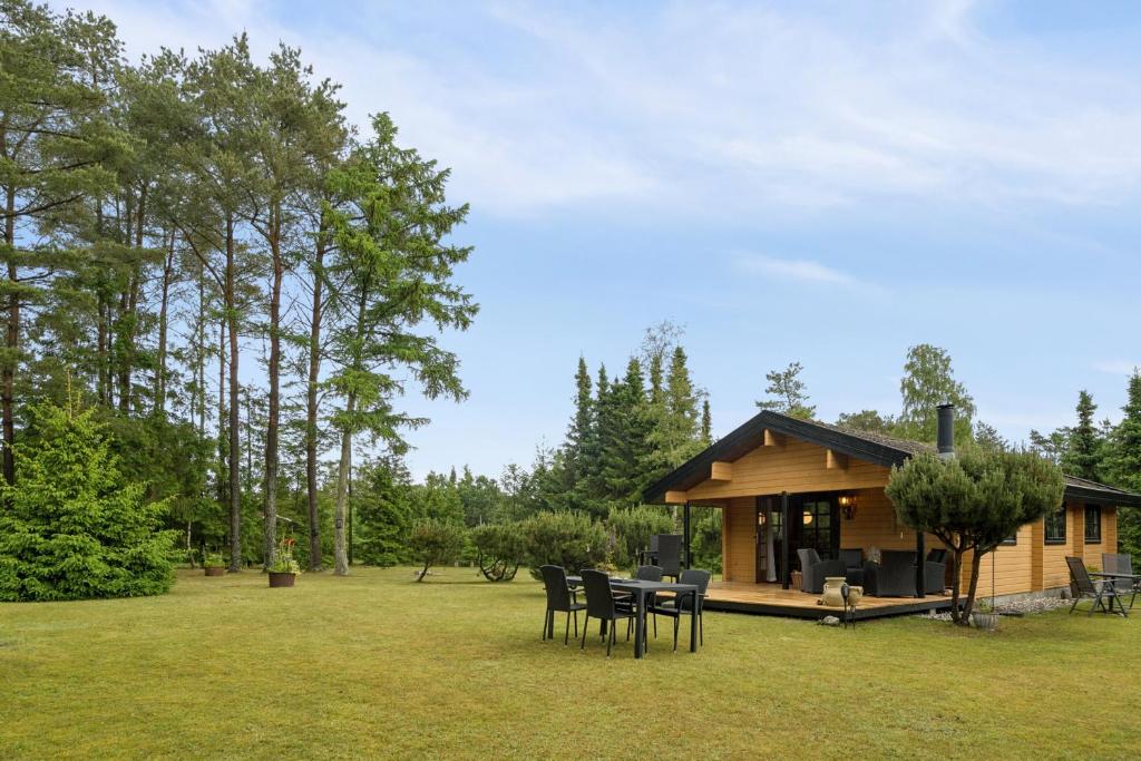 a cabin with a table and chairs in the grass at Peaceful Holiday Home Close To Nature in Glesborg