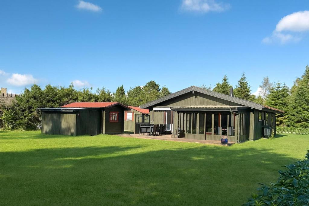 a house with a green lawn in front of it at The Pearl In Marielyst in Bøtø By