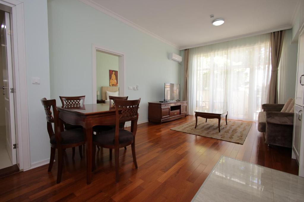 a dining room with a table and chairs and a living room at Apartman A4 - Dvorac Belimarkovic in Vrnjačka Banja