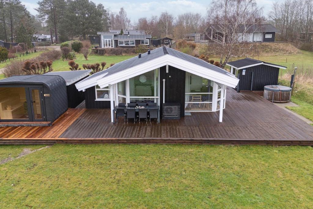 a black house with a white roof on a deck at Cozy Holiday Home On Orø in Orø