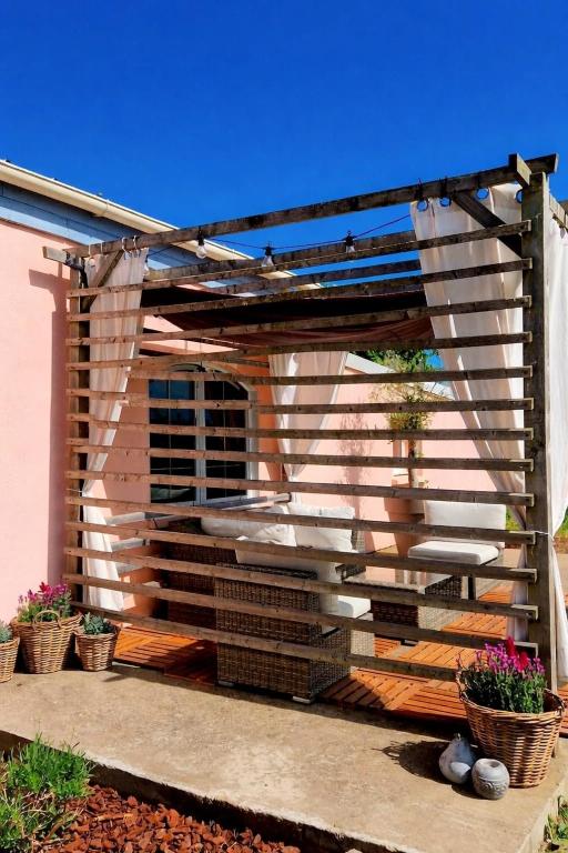 a wooden pergola with a bench and some plants at Écurie deL Luna in Cré-sur-Loir