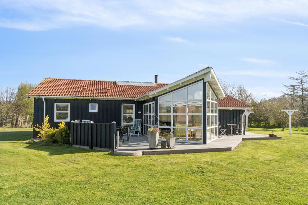 a small house with a large glass facade at Super Nice Holiday Home With Whirlpool in Højslev