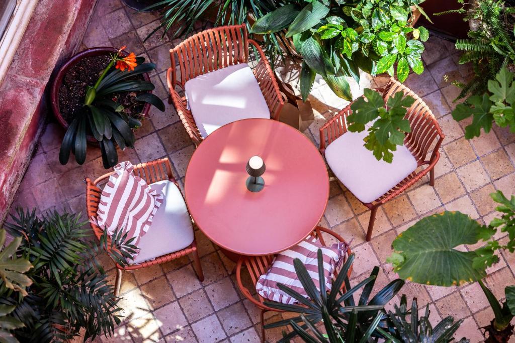 an overhead view of a table and chairs and plants at Hôtel Amphithéâtre in Arles