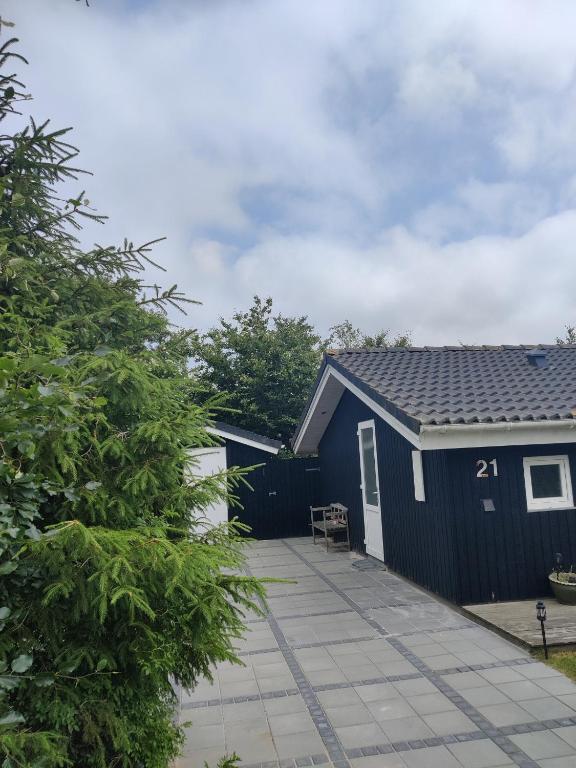 a blue shed with a patio in front of it at Fantastic Spa Holiday Home in Hemmet