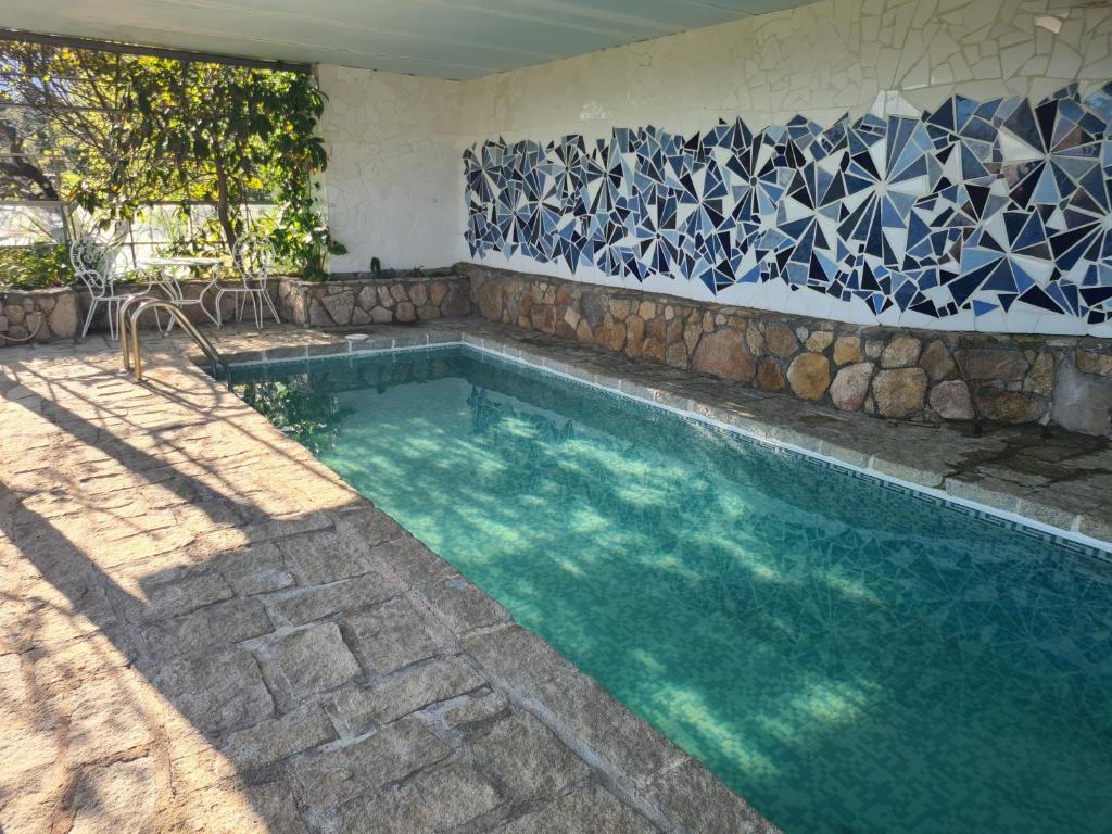 a swimming pool with a blue and white tile wall at El Valle in Piedralaves