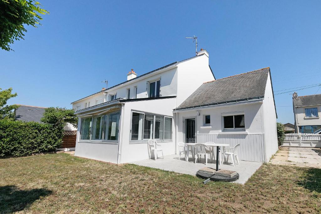 a white house with a table in a yard at Vacances chez Lulu in Batz-sur-Mer