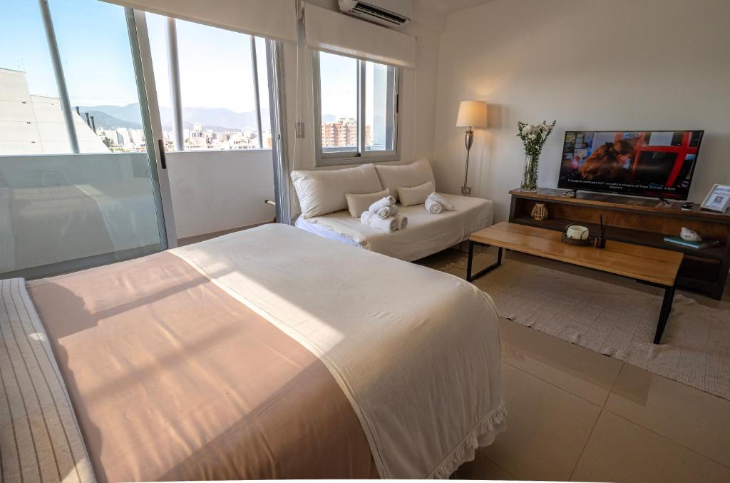a living room with a large bed and a couch at Delta Boutique Loft, en el centro de Salta, para 3 by BEDBOOK in Salta