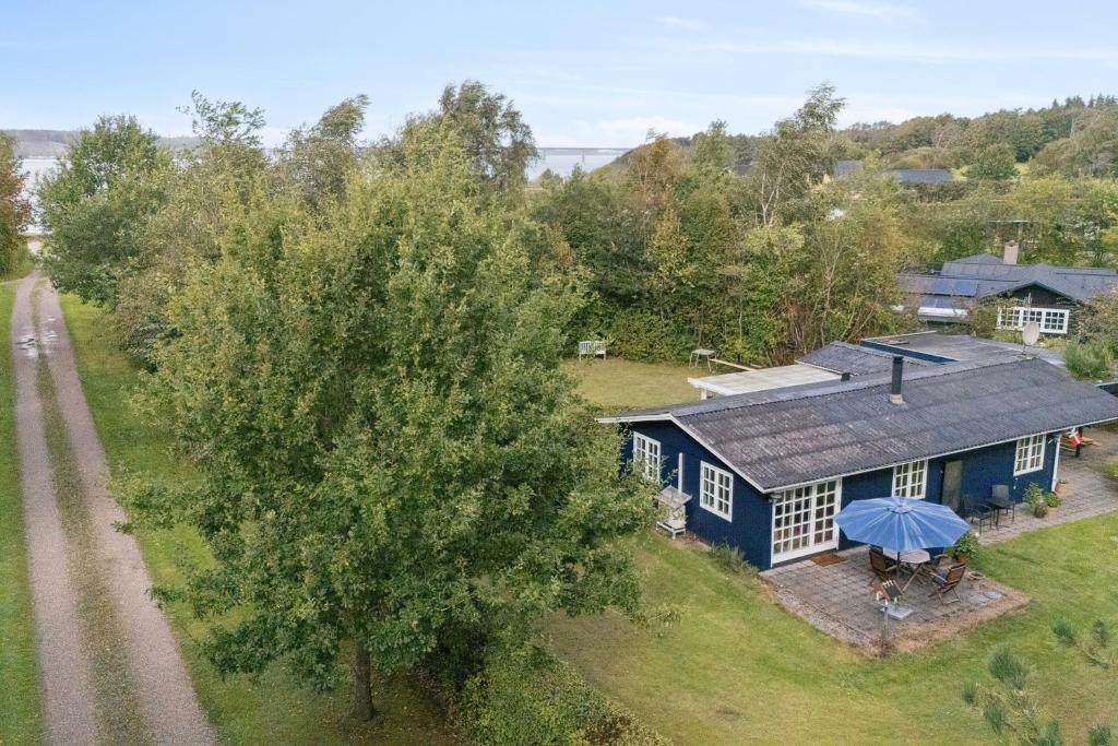an aerial view of a blue house with an umbrella at Renovated Classic Cottage Close To Beach in Roslev