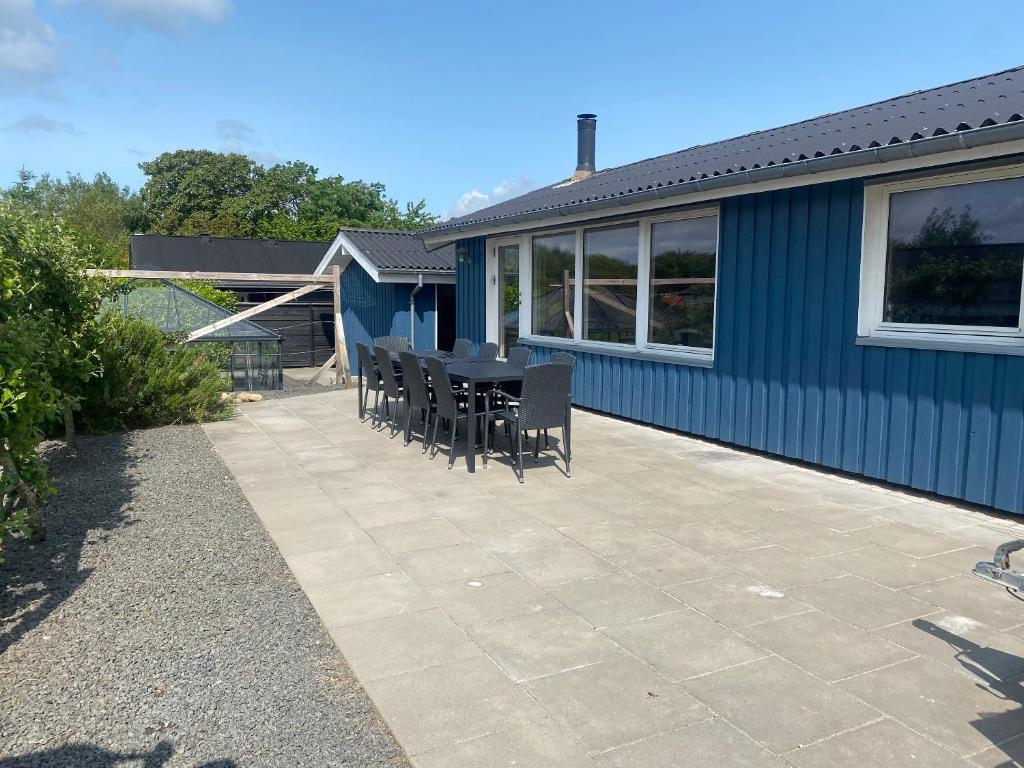 a patio with chairs and a table in front of a house at 2-Family Activity Cottage in Rønde