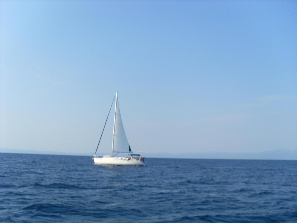 a white sailboat in the middle of the ocean at Studio Porto Marina in Sykia Chalkidikis
